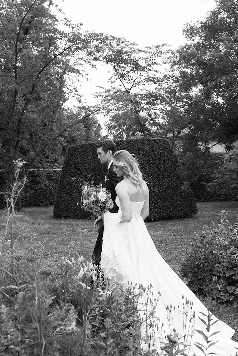 Una pareja de recién casados camina juntos en un hermoso jardín