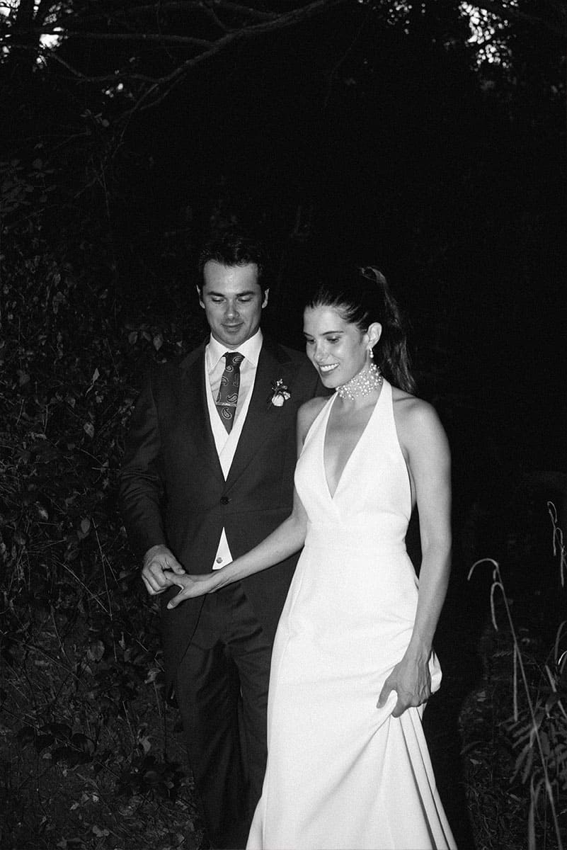 Una pareja de recién casados camina juntos bajo la luz nocturna