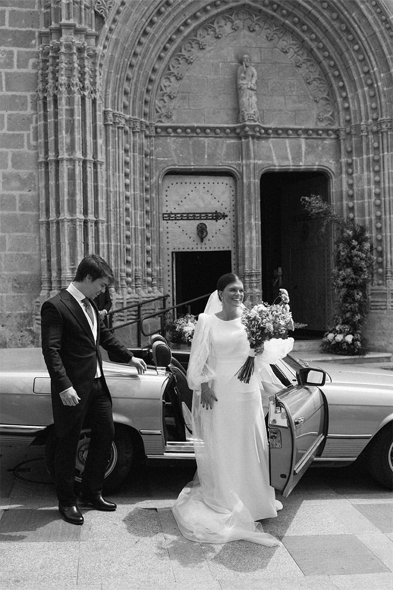 The bride and groom stand outside a grand church entrance